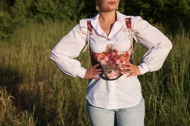Woman in beautiful corset outdoors, closeup. Space for text