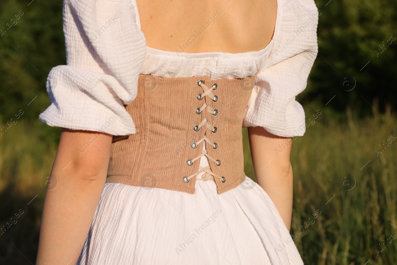 Photo of Woman in velvet corset outdoors, back view