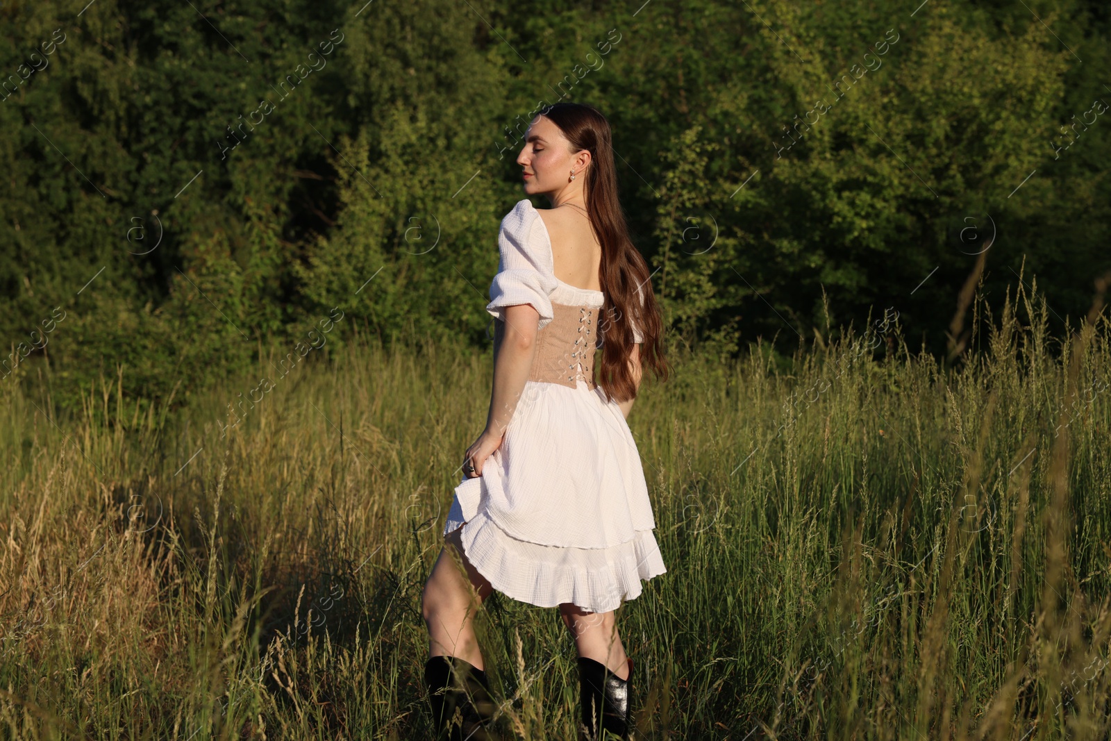 Photo of Beautiful woman in stylish corset posing outdoors