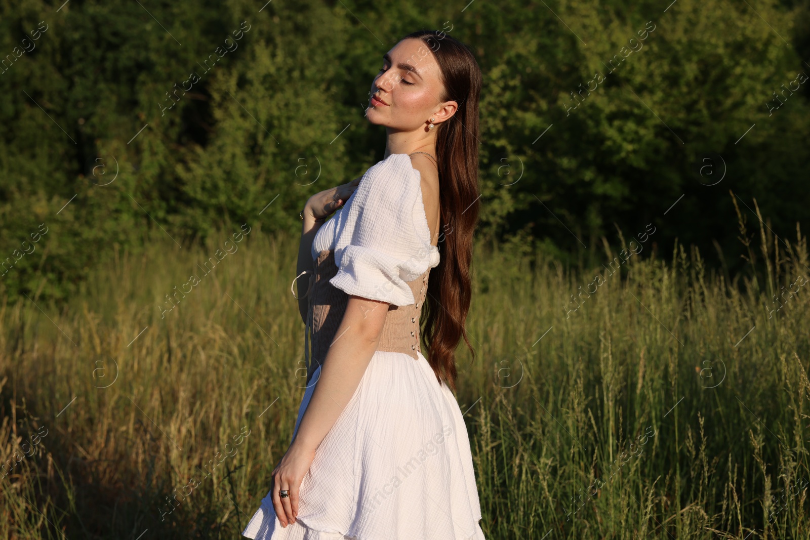 Photo of Beautiful woman in stylish corset posing outdoors