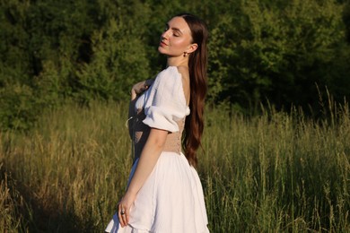 Photo of Beautiful woman in stylish corset posing outdoors