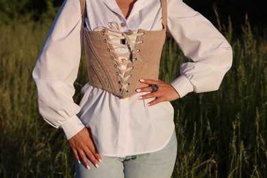 Woman in velvet corset posing outdoors, closeup