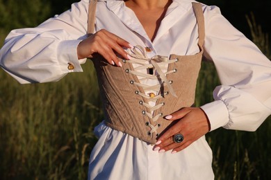 Photo of Woman in velvet corset posing outdoors, closeup