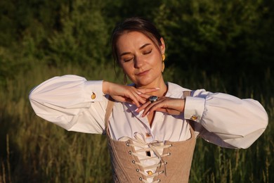 Photo of Beautiful woman in stylish corset posing outdoors