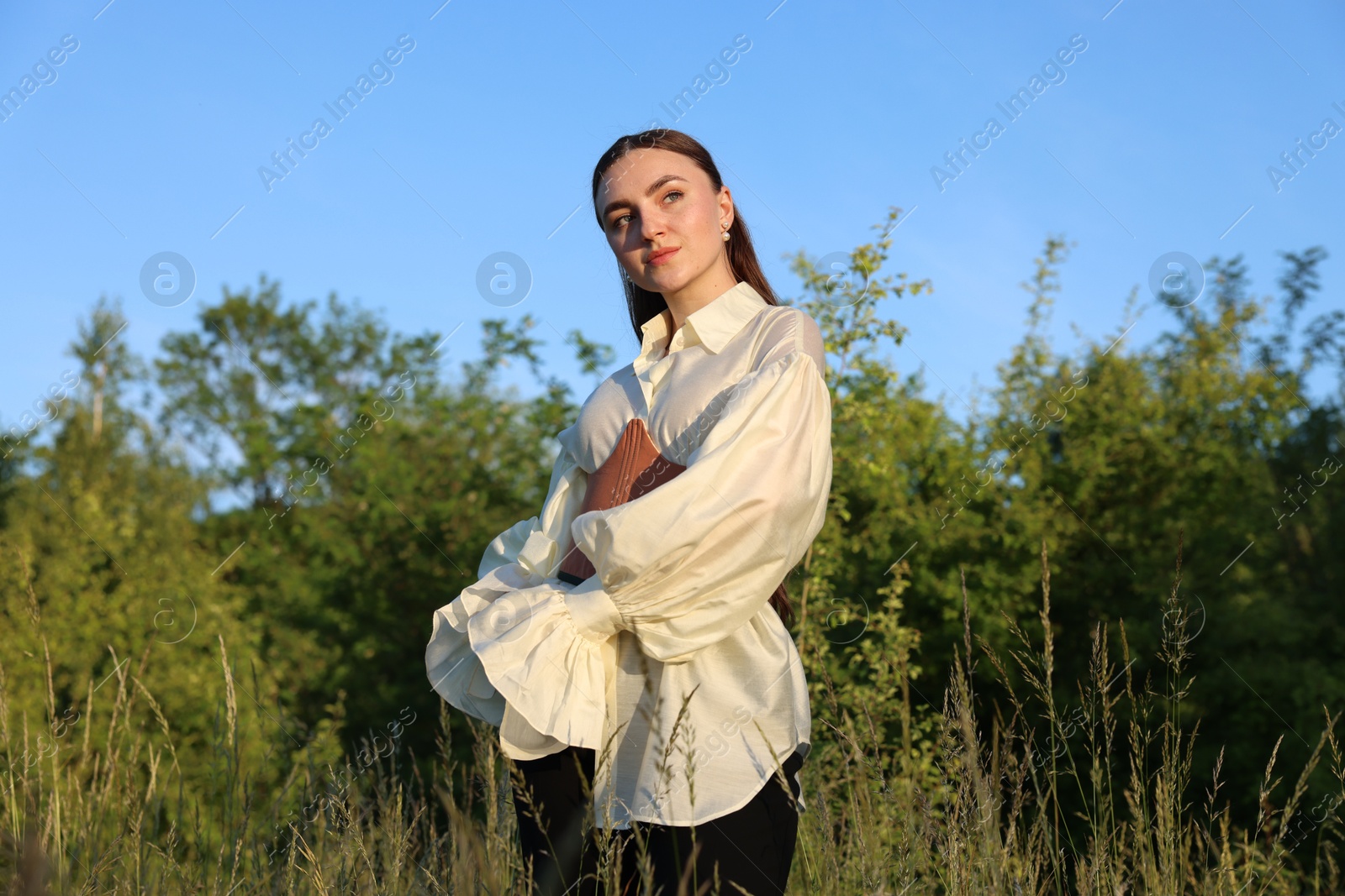 Photo of Beautiful woman in stylish corset posing outdoors, low angle view