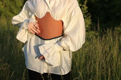 Woman in stylish corset posing outdoors, closeup