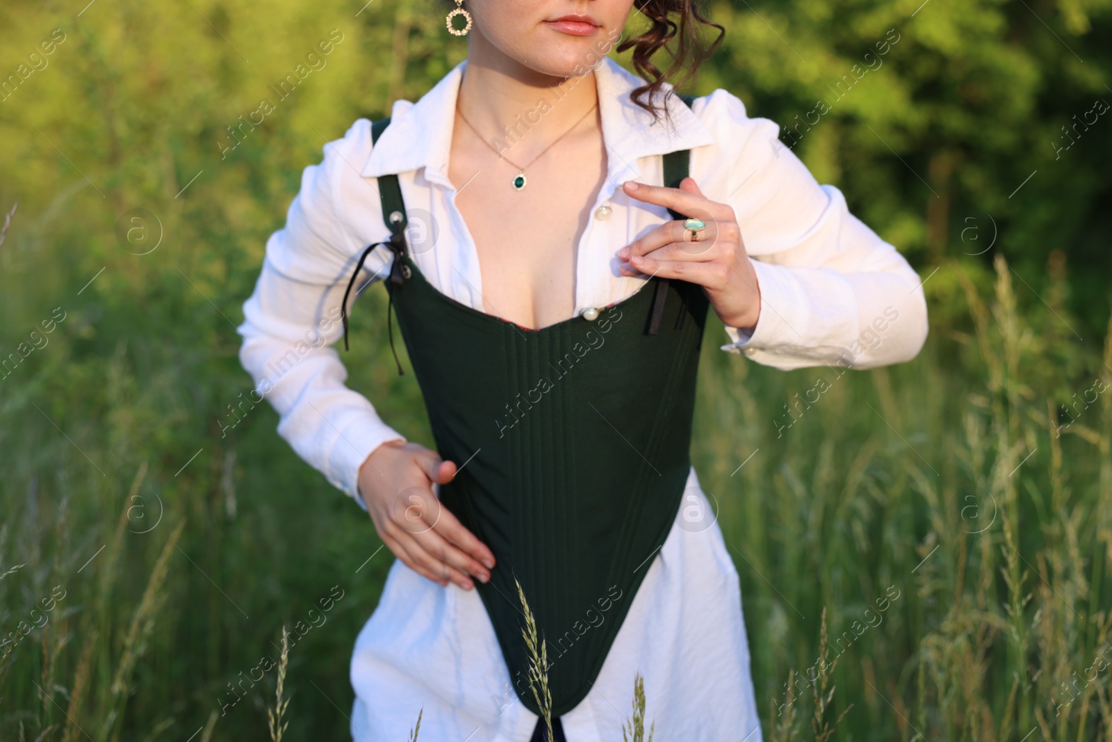 Photo of Woman in black corset posing outdoors, closeup