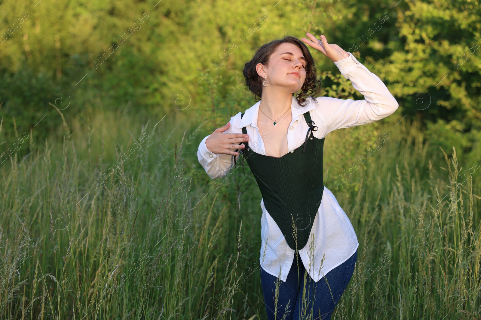 Photo of Beautiful woman in black corset posing outdoors. Space for text