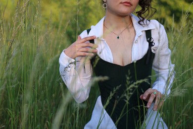 Photo of Woman in black corset posing outdoors, closeup