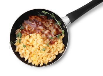 Delicious scrambled eggs with bacon in frying pan isolated on white, top view