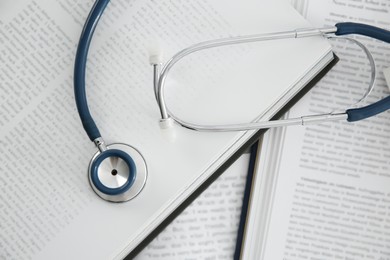 One new medical stethoscope and books on table, top view