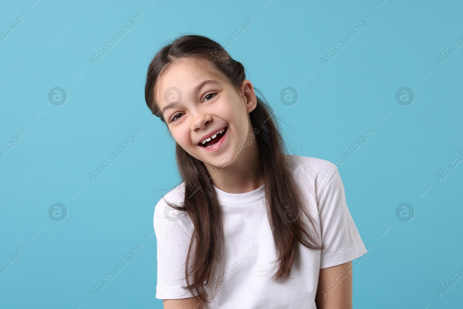 Photo of Portrait of happy girl on light blue background