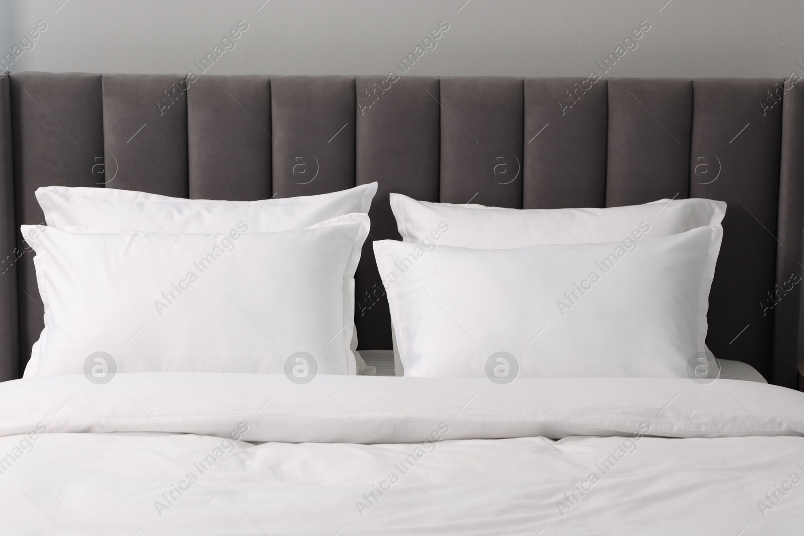 Photo of Many soft pillows on bed at home, closeup