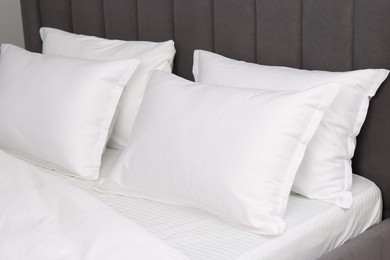 Photo of Many soft pillows on bed at home, closeup