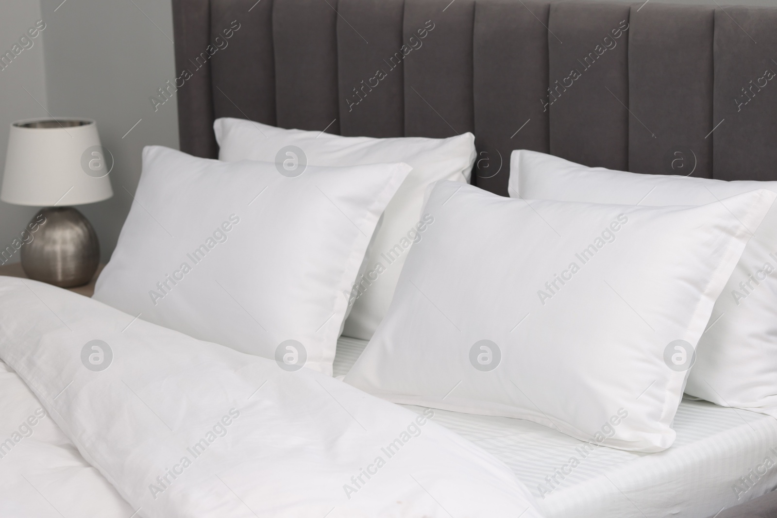 Photo of Many soft pillows on bed at home, closeup