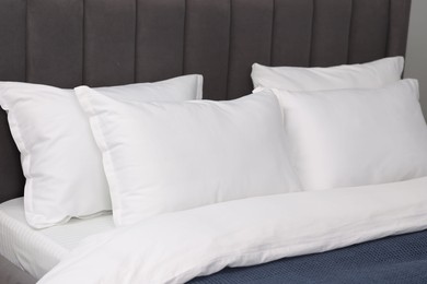 Photo of Many soft pillows on bed at home, closeup