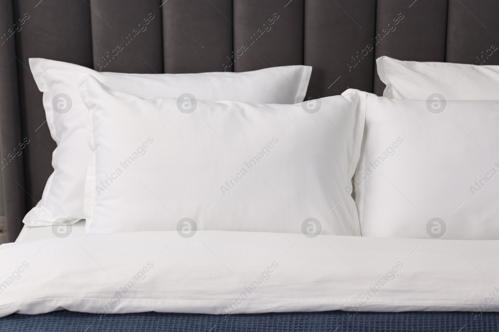 Photo of Many soft pillows on bed at home, closeup