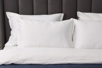 Photo of Many soft pillows on bed at home, closeup