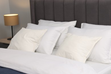 Photo of Many soft pillows on bed at home