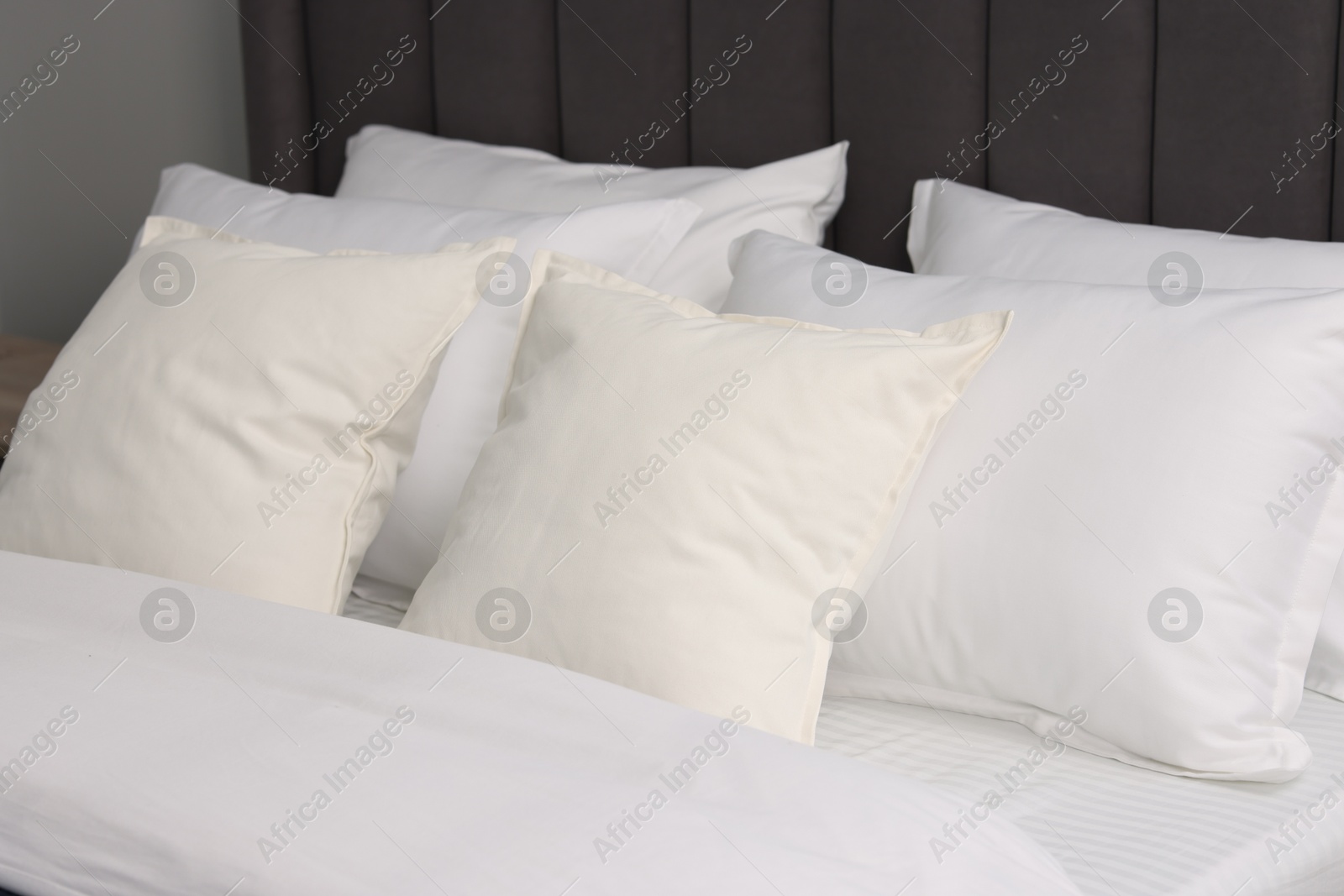 Photo of Many soft pillows on bed at home, closeup