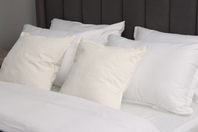 Photo of Many soft pillows on bed at home, closeup