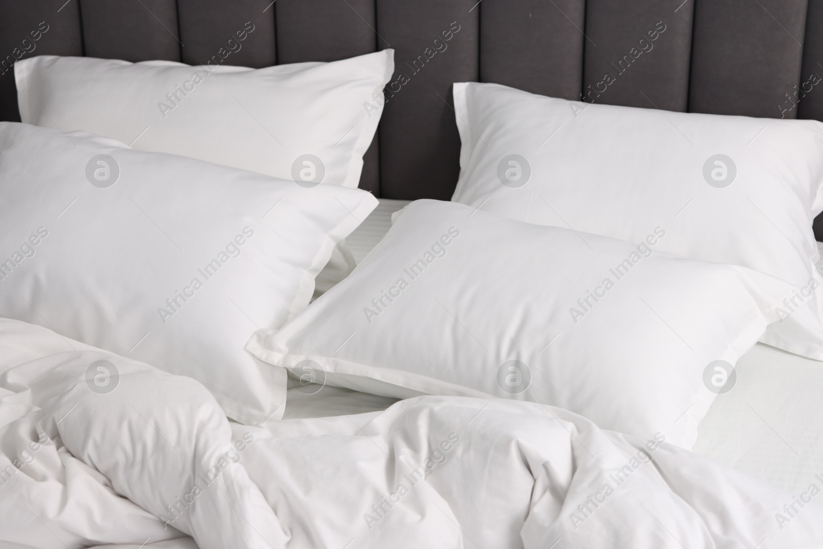 Photo of Many soft pillows on bed at home, closeup