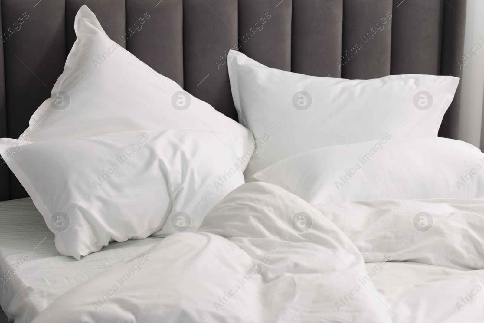 Photo of Many soft pillows on bed at home, closeup