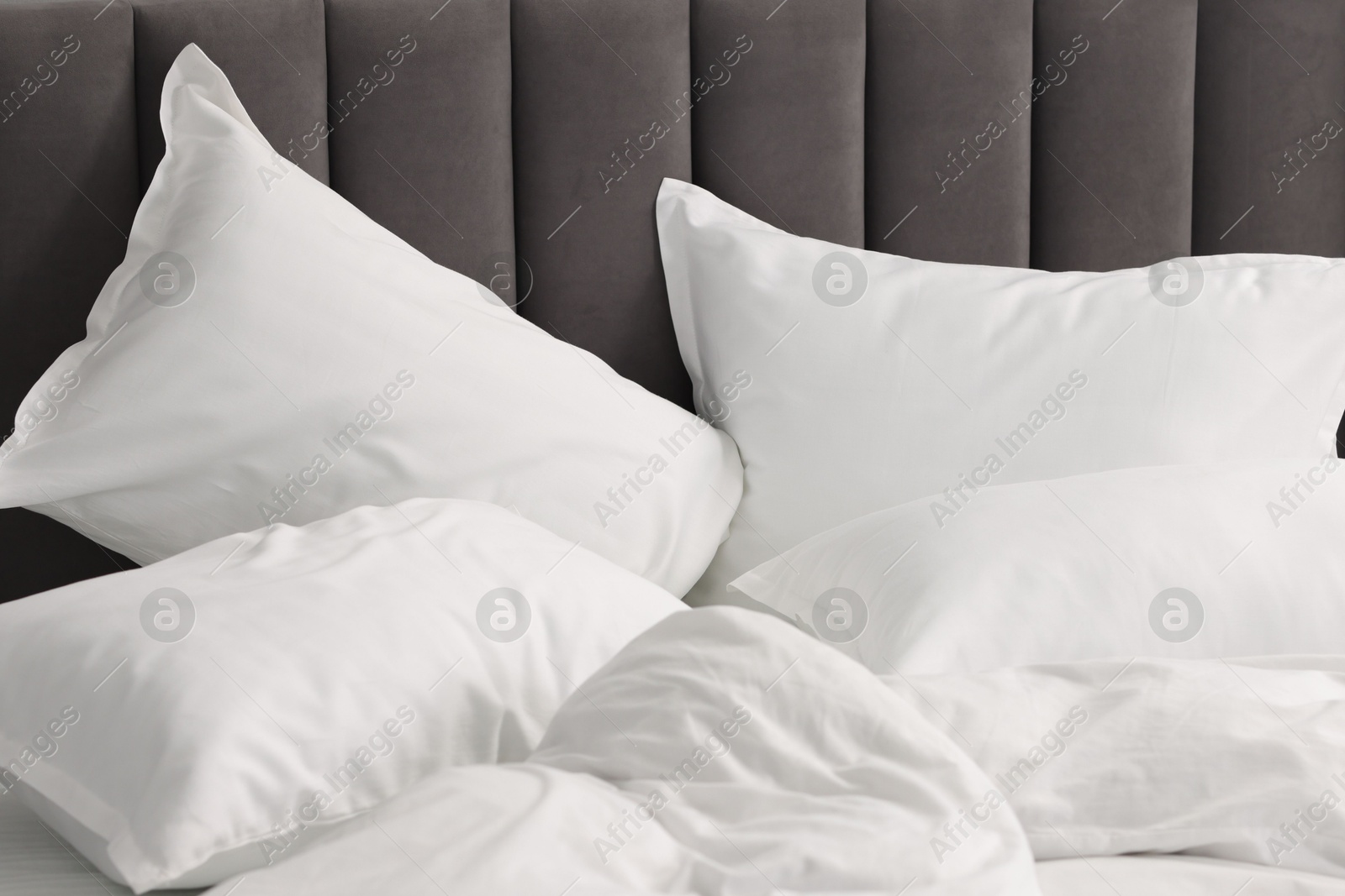 Photo of Many soft pillows on bed at home, closeup