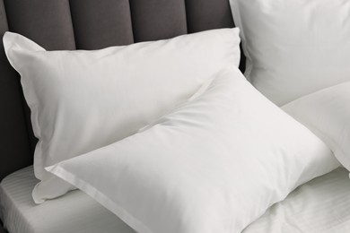 Photo of Many soft pillows on bed at home, closeup