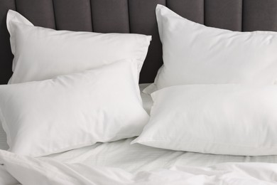 Many soft pillows on bed at home, closeup