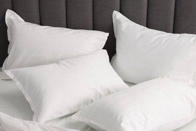 Photo of Many soft pillows on bed at home, closeup