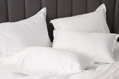 Many soft pillows on bed at home, closeup