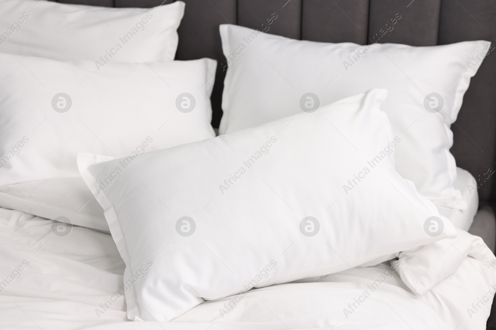 Photo of Many soft pillows on bed at home, closeup