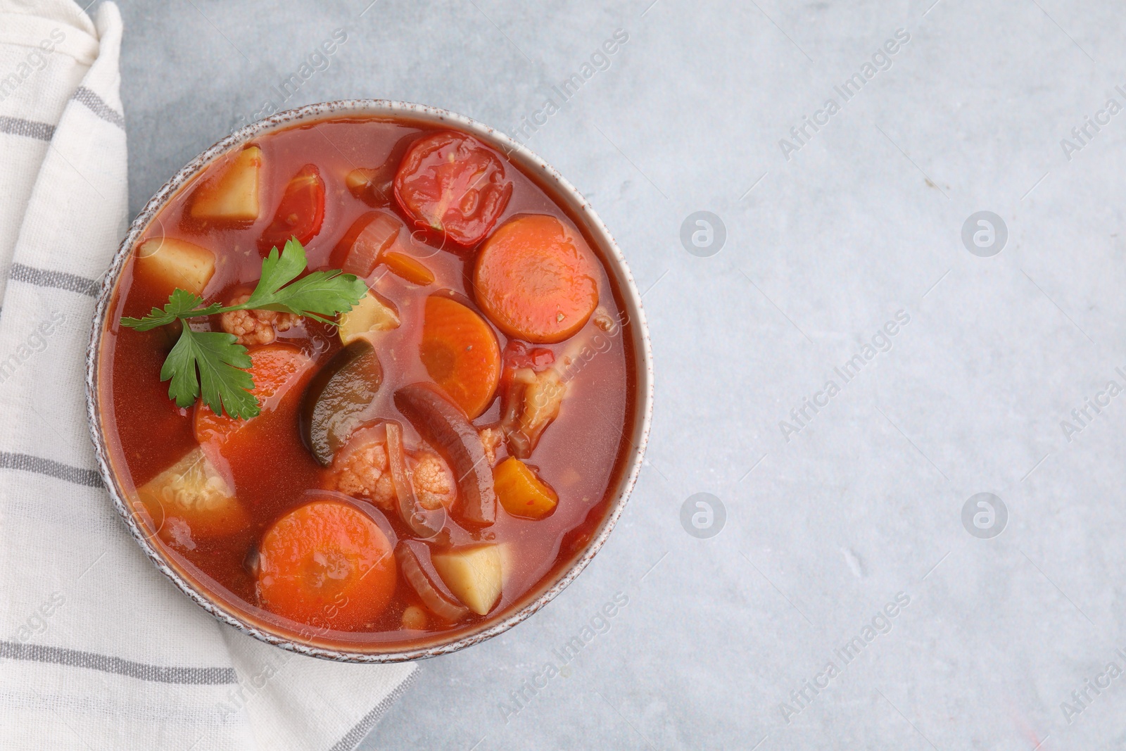 Photo of Delicious homemade stew in bowl on light table, top view. Space for text