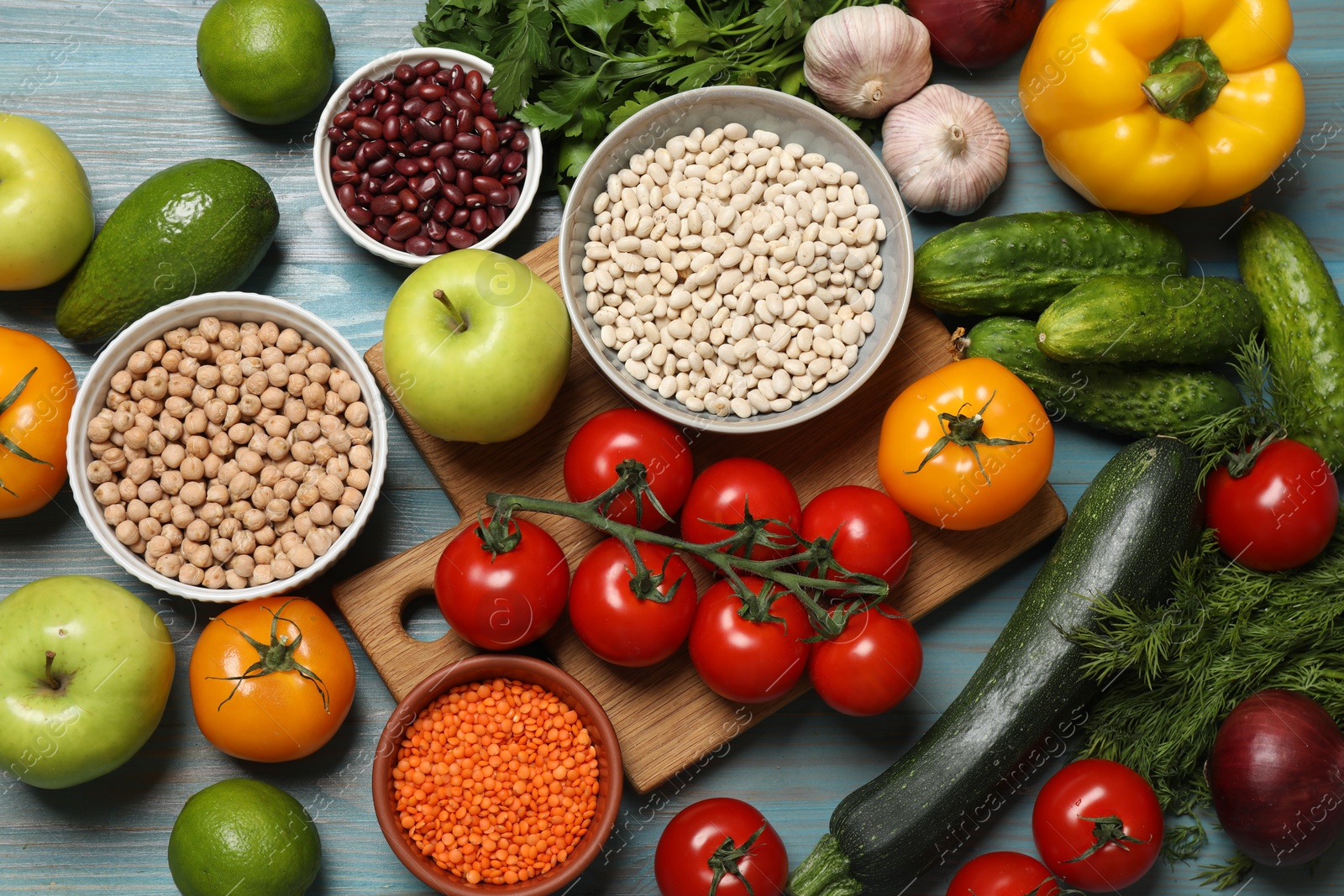 Photo of Different vegetarian products on light blue wooden table, top view