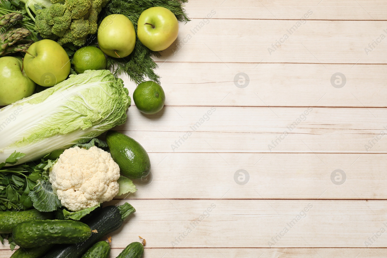 Photo of Different vegetarian products on light wooden table, top view. Space for text