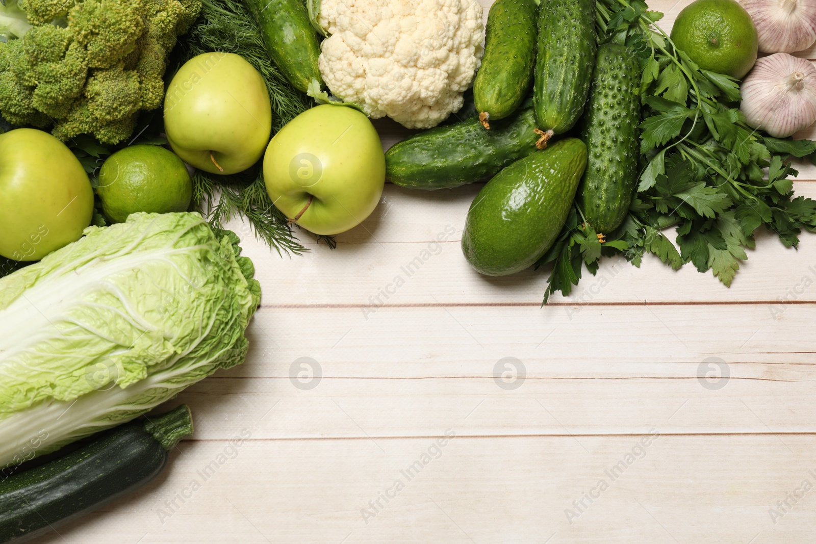 Photo of Different vegetarian products on light wooden table, top view. Space for text