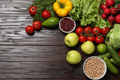 Photo of Different vegetarian products on wooden table, top view. Space for text