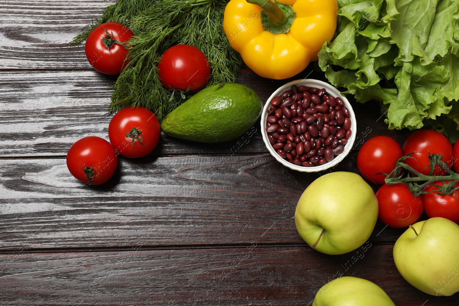 Photo of Different vegetarian products on wooden table, top view. Space for text