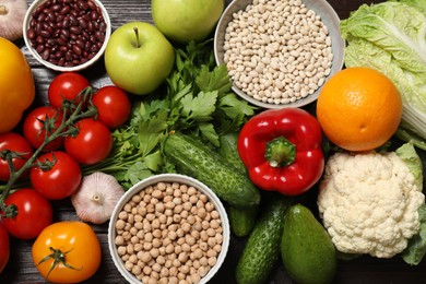 Photo of Different vegetarian products on wooden table, top view