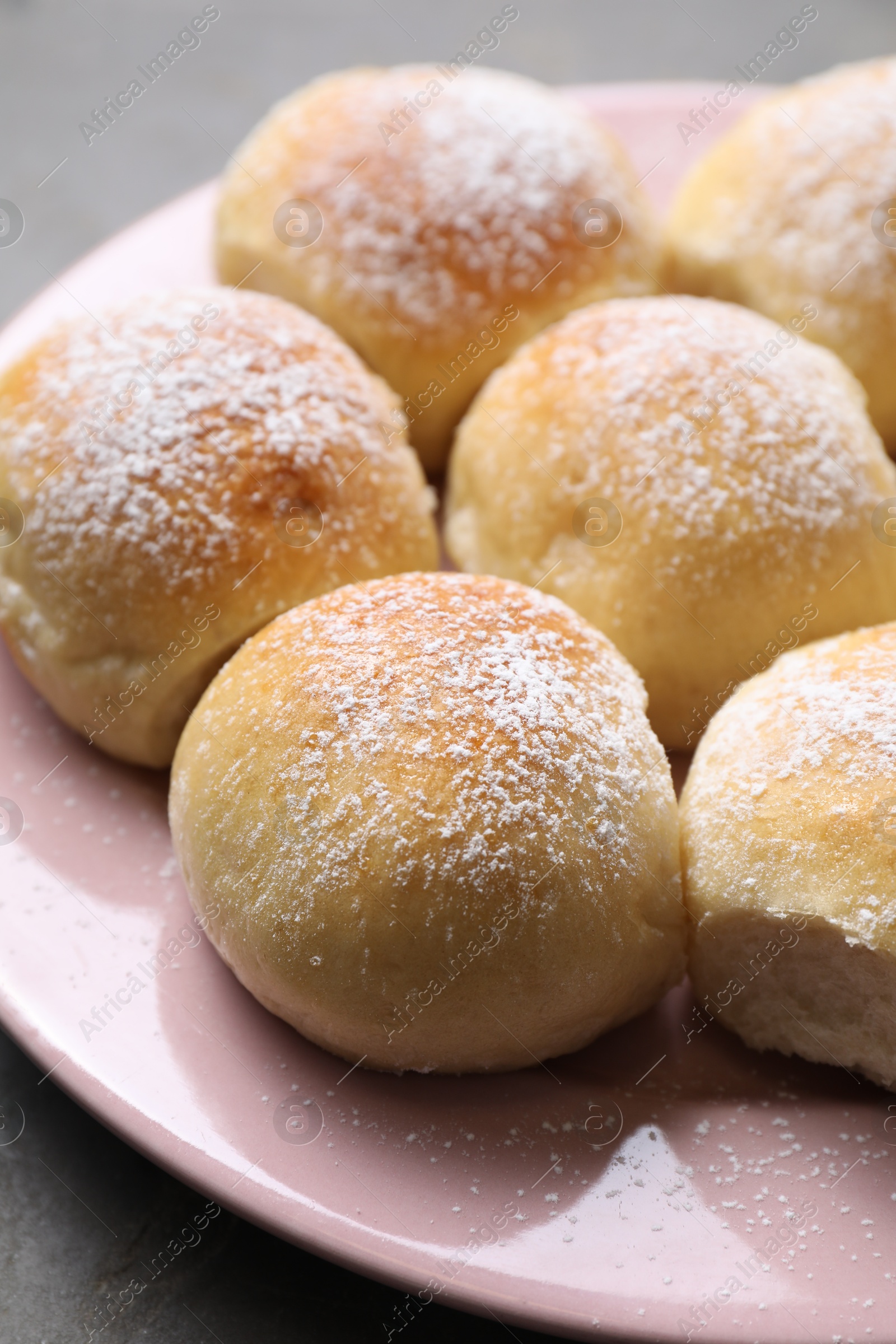 Photo of Delicious dough balls with powdered sugar on table