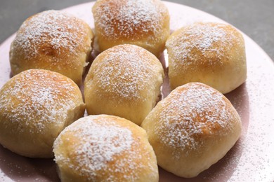 Photo of Delicious dough balls with powdered sugar on table, closeup