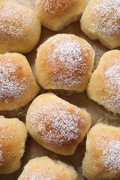 Photo of Delicious dough balls on parchment paper, top view