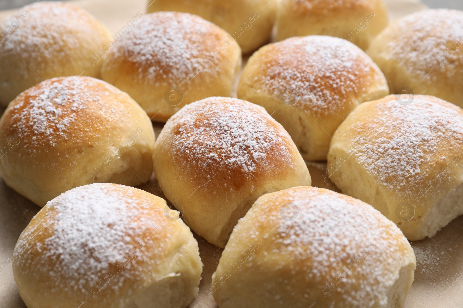 Photo of Delicious dough balls on parchment paper, closeup