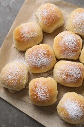 Delicious dough balls with powdered sugar on grey table, top view