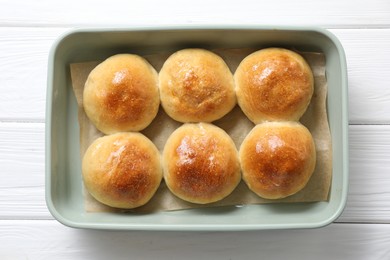 Delicious dough balls in baking dish on white wooden table, top view