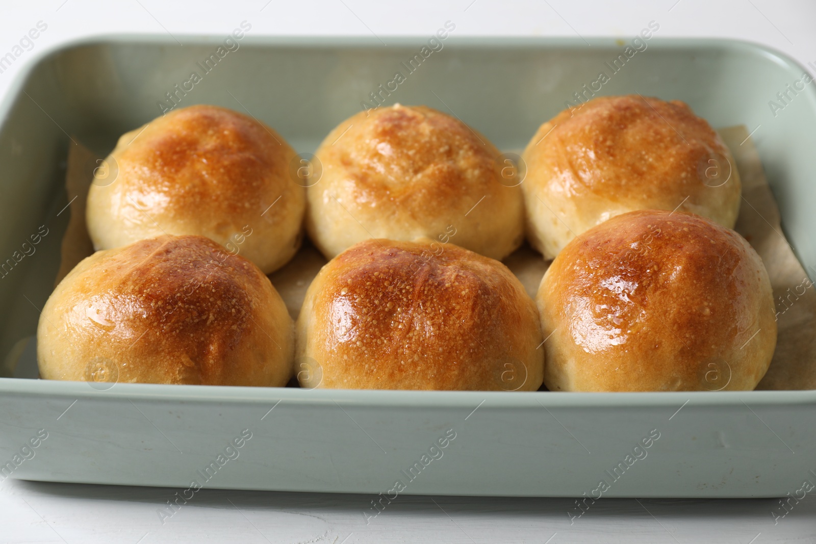 Photo of Delicious dough balls in baking dish on white table