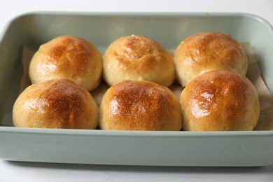 Delicious dough balls in baking dish on white table