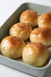 Delicious dough balls in baking dish on white table