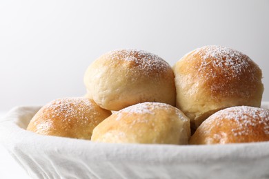 Delicious dough balls in basket on light background